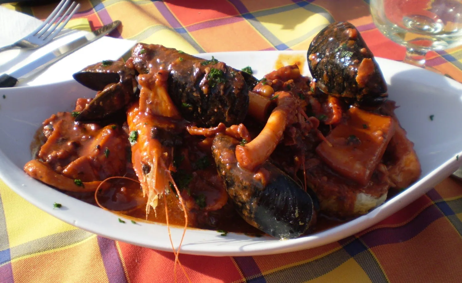 Cacciucco, zuppa di pesce e crostacei tipica della costa toscana, servita su fetta di pane
